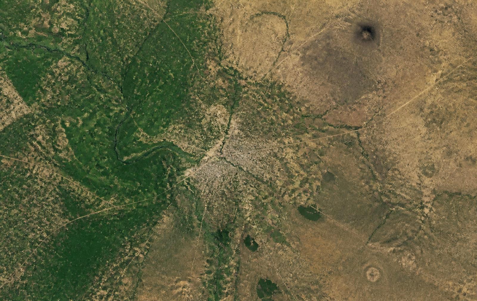 Satellite view of a Kenyan county with farmland, a town and roads.